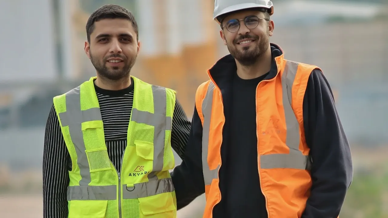 Two construction workers in high-visibility vests